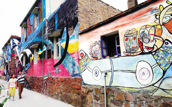 嵊泗县五龙乡田岙村把渔民画搬上了村民住房的外墙,昔日的普通小渔村变成了风情独特的渔民画"壁画村".