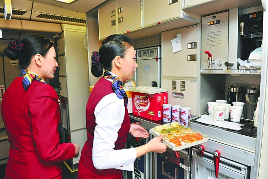 2月23日,在国航a330包机上,空中乘务员正在准备餐食.   新华社发